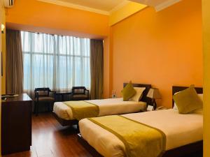 una camera d'albergo con due letti e una finestra di Airport Hotel a Kathmandu