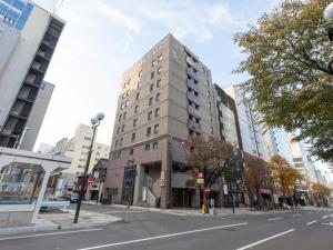 a tall building on the corner of a city street at Tabist THE GREEN SAPPORO in Sapporo