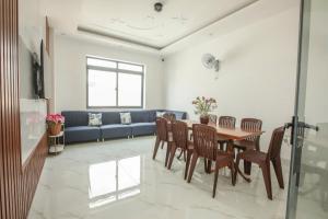 a living room with a table and chairs and a blue couch at Villa Homestay Sumo in Vung Tau