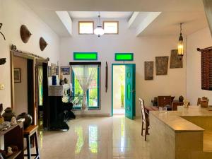 a living room with green doors and a table at Frangipani garden villa in Senggigi +18 photos