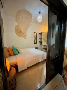 a bedroom with a bed and a chandelier at Frangipani garden villa in Senggigi 