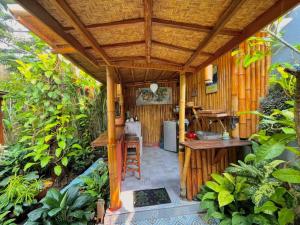 an outdoor kitchen with a wooden pergola at Frangipani garden villa in Senggigi