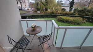 Un balcón con una mesa con un jarrón de flores. en Maghy Appart à Strasbourg, en Estrasburgo
