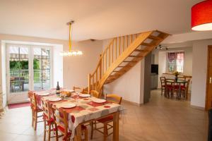 a dining room with a table and a staircase at Gite b les pres in Chadenet