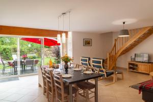 a dining room and living room with a table and chairs at Gîte a les rosiers in Chadenet