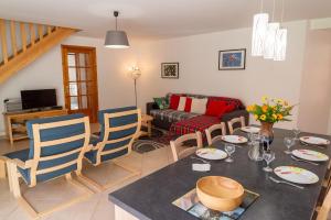 a kitchen and living room with a table and chairs at Gîte a les rosiers in Chadenet