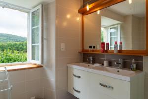 a bathroom with two sinks and a window at Gîte a les rosiers in Chadenet +16 photos
