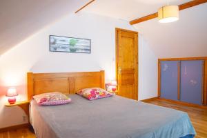 a bedroom with a bed with two pillows on it at Gîte a les rosiers in Chadenet