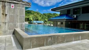 a swimming pool next to a building at Ngermid Oasis - Charming 1 BD/1.5 BA Duplex in Koror