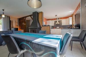 a kitchen with a table with chairs and a stove at La grande sablonniere in La Ville-aux-Bois +8 photos