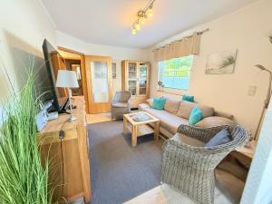 un soggiorno con un divano e una TV di Residenz am Yachthafen, Whg 8 a Grömitz