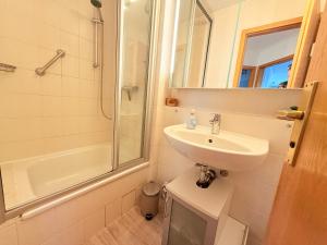 un bagno bianco con lavandino e doccia di Residenz am Yachthafen, Whg 8 a Grömitz Altre 10 foto