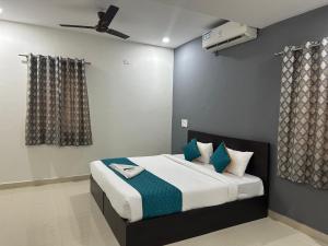 a bedroom with a bed with blue pillows and a fan at Hotel Deccan Retreat in Hyderabad +16 photos