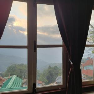 a window with a view of a city at Mudita Stays in Darjeeling