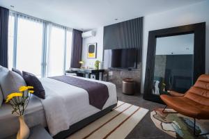 ein Schlafzimmer mit einem Bett, einem Stuhl und einem Spiegel in der Unterkunft Umalas Creek Villas in Canggu