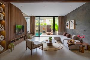 una sala de estar con un sofá y una mesa en Umalas Creek Villas, en Canggu