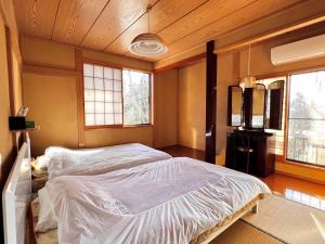 een slaapkamer met een bed in een kamer met ramen bij 那須別荘 那須エデン in Nasu +32 foto's