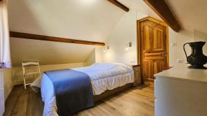 a bedroom with a bed with a blue blanket at Le fournil in Marcillac-la-Croisille
