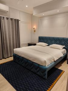 バンガロールにあるElegance & Comfort near MG Roadのベッドルーム1室(大型ベッド1台、青いヘッドボード付)