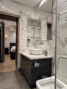 バンガロールにあるElegance & Comfort near MG Roadの洗面台と鏡のある白いバスルーム