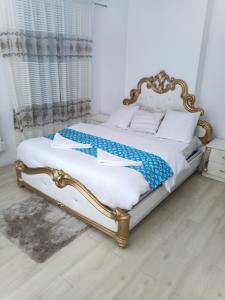 1 cama con marco de oro en un dormitorio en Résidence les jardins secrets, en Romilly-sur-Seine