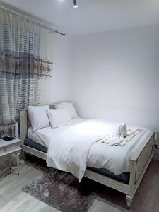 Un dormitorio con una cama con un osito de peluche encima. en Résidence les jardins secrets, en Romilly-sur-Seine