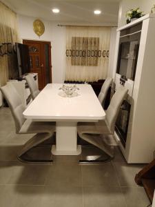 Un comedor blanco con una mesa y sillas blancas. en Résidence les jardins secrets, en Romilly-sur-Seine 28 fotos más
