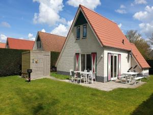 a house with a table and chairs in the yard at Modern Beach Retreat Sauna in Breskens