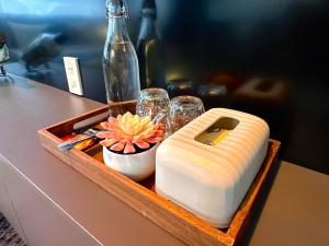 a wooden tray with a bottle and glasses and a flower at Spring Home in Can Tho