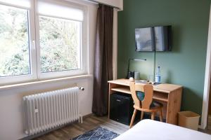 a room with a desk and a window at Kreilingshöfchen Apartments in Bad Vilbel