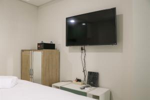 Un televisor de pantalla plana colgado en una pared en Elegant and Comfy Studio at Daan Mogot City Apartment By Travelio, en Yakarta