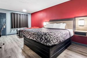 a bedroom with a bed and a red wall at Econo Lodge Kennett in Kennett +33 photos