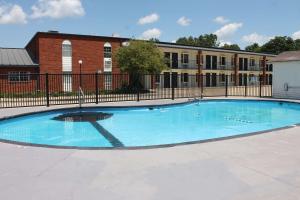 a large blue swimming pool in front of a building at Econo Lodge Kennett in Kennett
