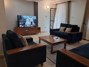 a living room with a couch and a tv at Elena & Kimberly Residences in Gulu