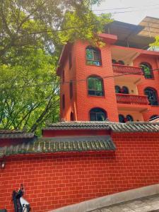 a red brick building with a man on a motorcycle in front at Kaibu Courtyard Superior Apartment, Changjiang Cable Car Nanbin Road, Chongqing in Chongqing
