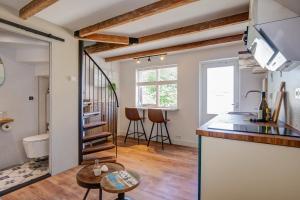 eine Küche und ein Wohnzimmer mit einer Wendeltreppe in der Unterkunft Tiny Beachhouse Petten in Petten