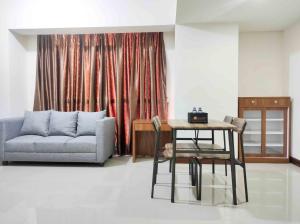 a living room with a couch and a table at Big and Comfy 3BR at Vida View Apartement By Travelio in Pampang