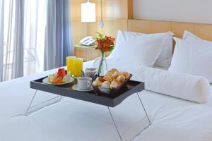 a bed with a tray of food on top of it at Royal Golden Hotel - Savassi in Belo Horizonte