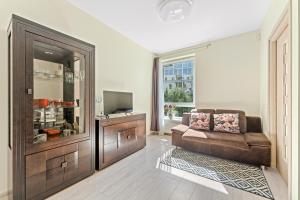 a living room with a couch and a television at A4 Ozo park apartments in Vilnius
