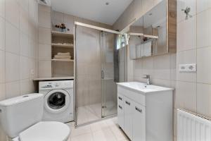 a bathroom with a washing machine and a sink at A4 Ozo park apartments in Vilnius