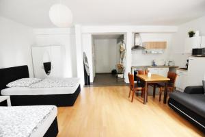 ein Zimmer mit zwei Betten und einem Tisch und einer Küche in der Unterkunft Dorya am Ring in Köln + 37 Fotos