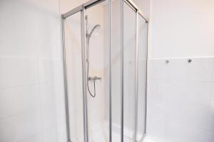 eine Dusche mit einer Glastür in einem Badezimmer in der Unterkunft Dorya am Ring in Köln