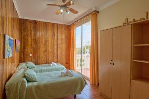 a bedroom with a bed with a ceiling fan and a window at Villa Santa Ana en La Carlota in La Carlota