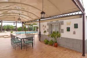 a patio with a table and chairs and a pool at Villa Santa Ana en La Carlota in La Carlota