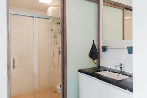łazienka z umywalką i prysznicem w obiekcie Elegant and Strategic 2BR Sky House BSD Apartment By Travelio w mieście Tangerang +6 zdjęć