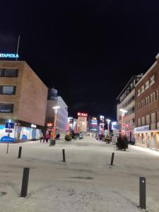 an empty street at night with buildings and lights at Main Street magic apartment in Rovaniemi