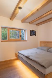 a bedroom with a bed and two windows at Pilnikárna in České Křižánky