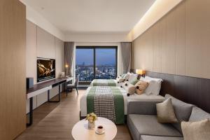 a hotel room with a bed and a couch at Ascott Fengyishan Shenzhen in Shenzhen