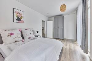 Un dormitorio blanco con una gran cama blanca con flores. en Zentral und ruhig Netflix Balkon Parkplatz, en Bruchsal