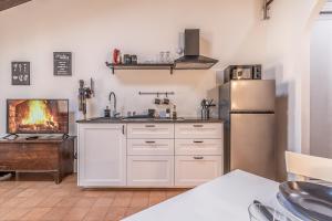 a kitchen with a refrigerator and a fire in the fireplace at [Chardonnay]- elegante appartamento in Cavezzo